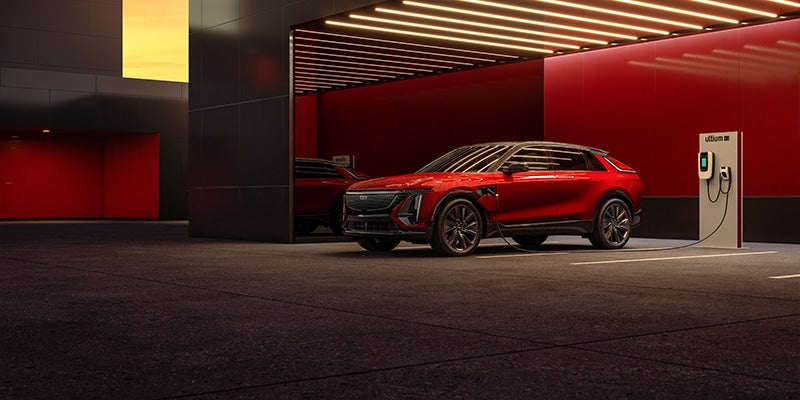 Red 2024 Cadillac LYRIQ charging in a red parking garage