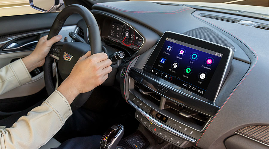 Driver using Cadillac touchscreen infotainment, highlighting AC system controls